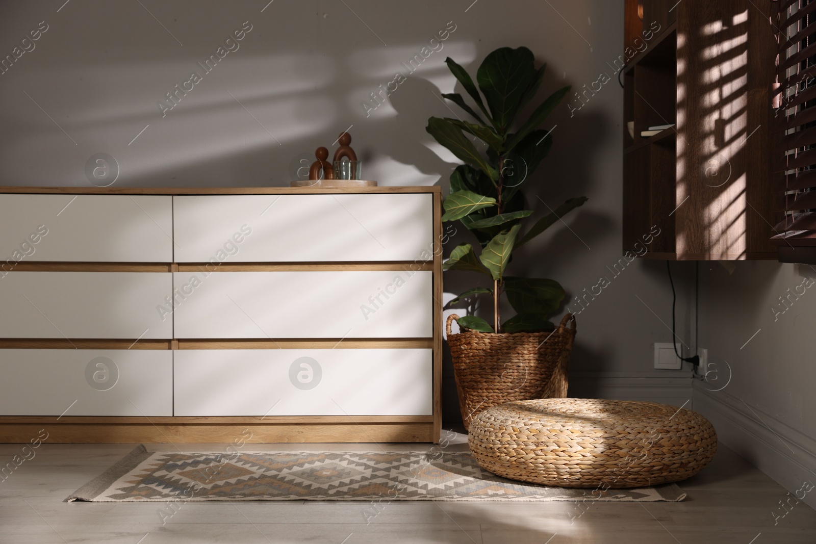 Stylish wicker pouf and home decor indoors Photo of Stylish wicker pouf and home decor indoors