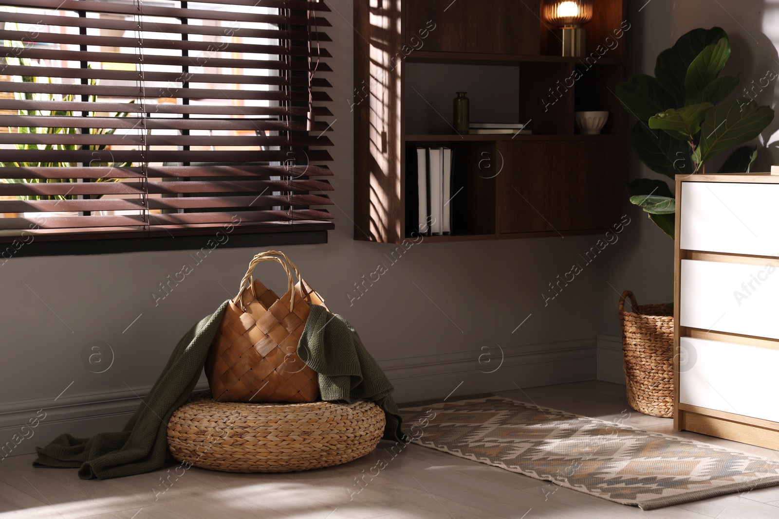 Wicker pouf and basket with plaid at home Photo of Wicker pouf and basket with plaid at home