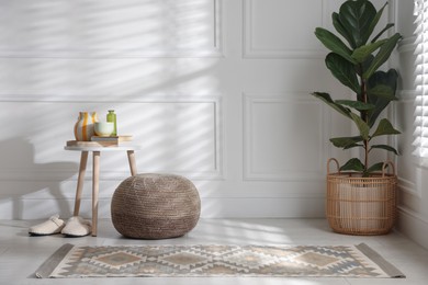 Photo of Stylish knitted pouf and home decor indoors