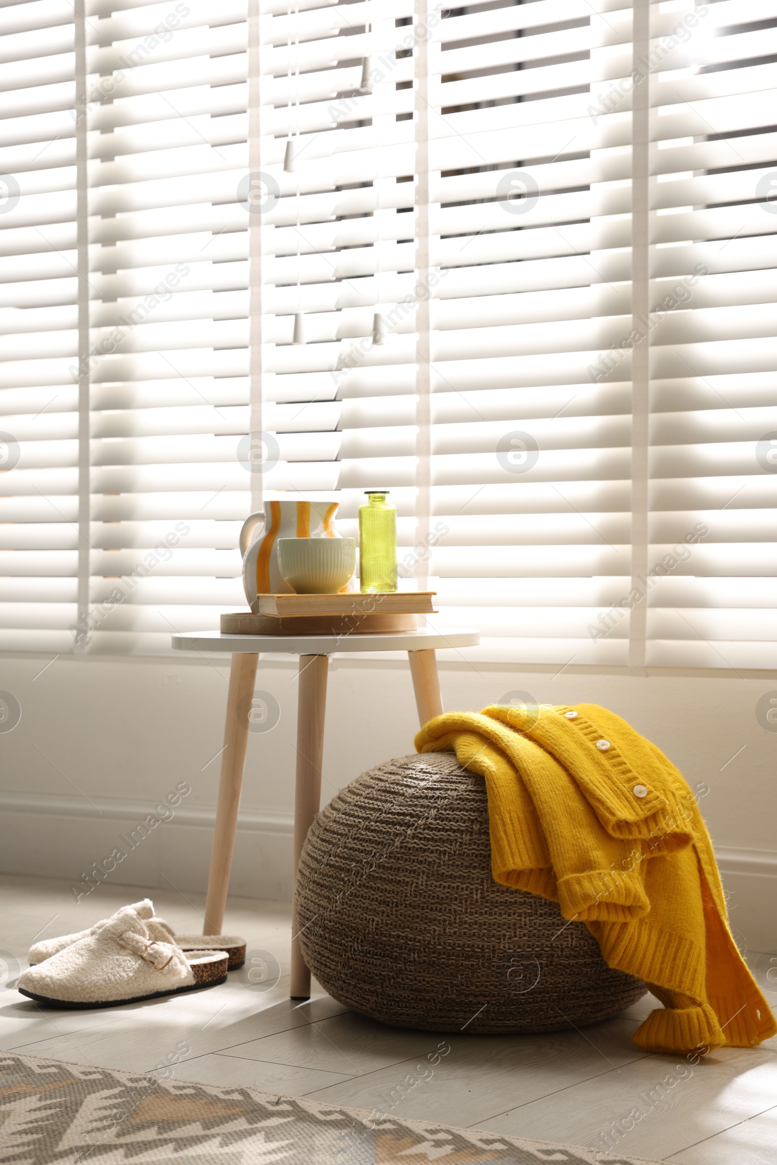 Photo of Stylish knitted pouf with sweater at home