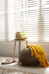Photo of Stylish knitted pouf with sweater at home