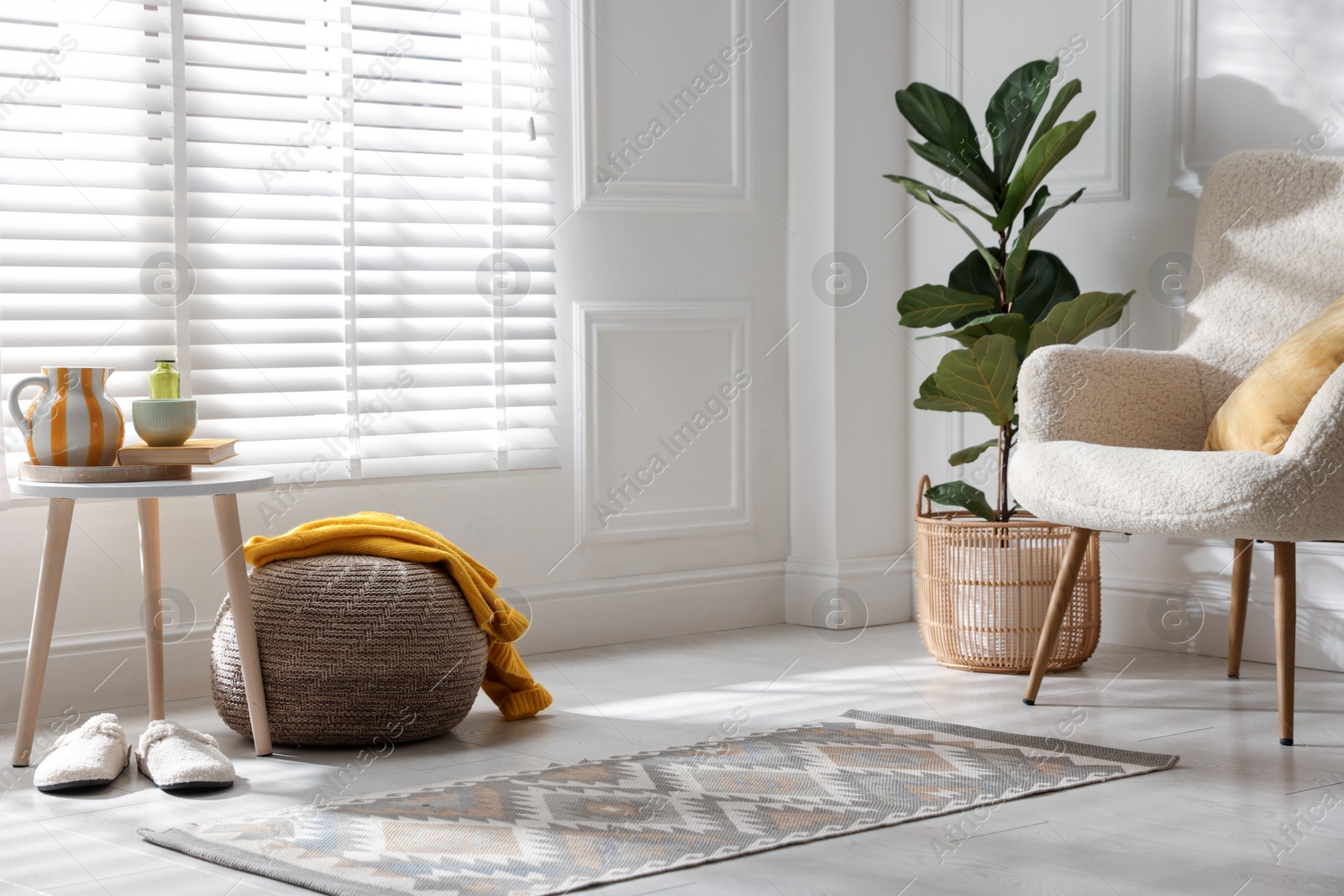Stylish knitted pouf with sweater at home Photo of Stylish knitted pouf with sweater at home