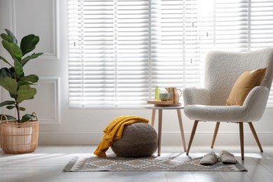 Photo of Stylish knitted pouf with sweater at home