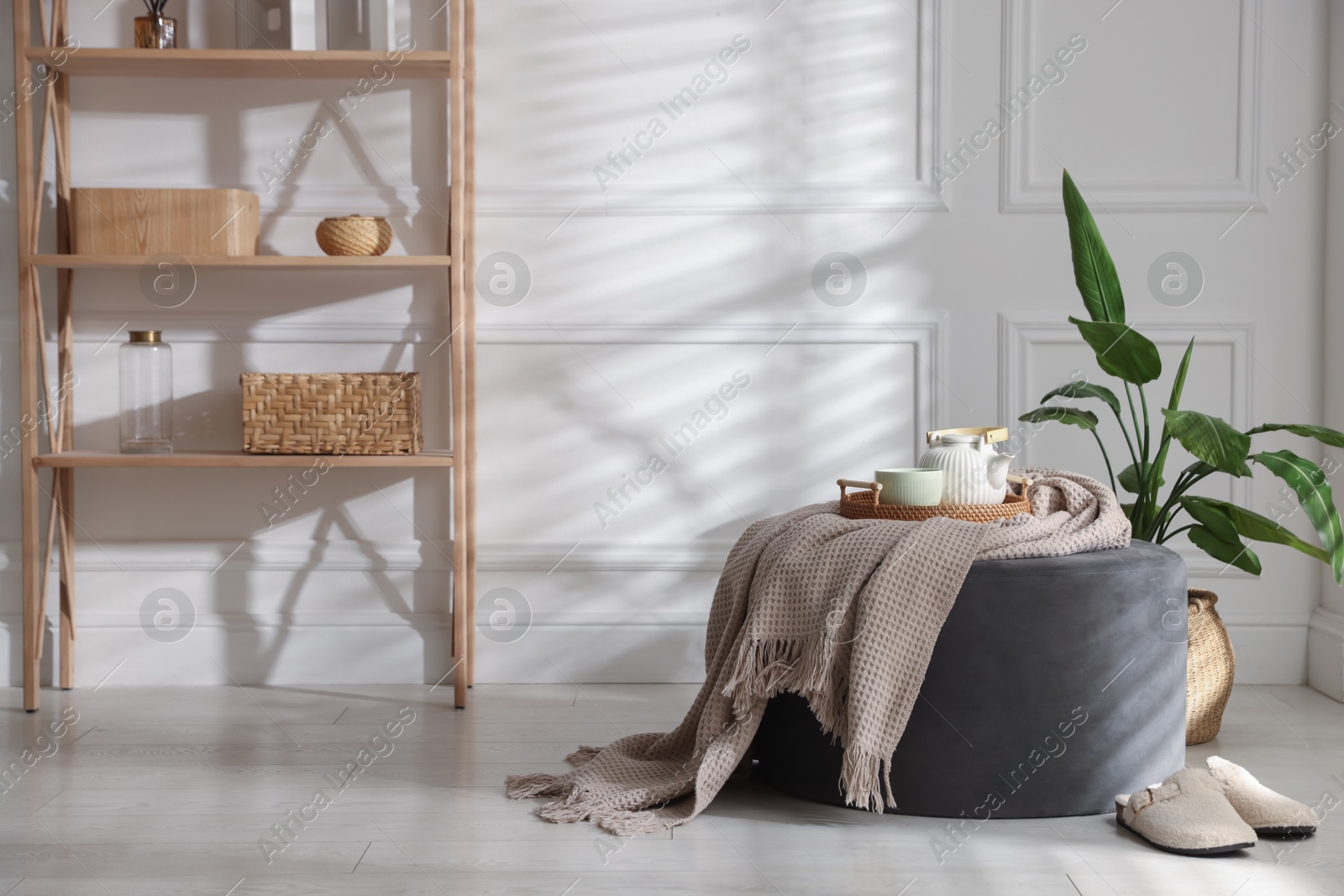 Photo of Stylish pouf with tea set at home
