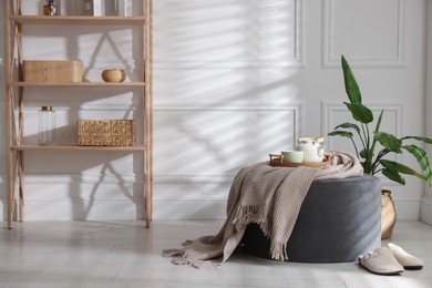 Photo of Stylish pouf with tea set at home
