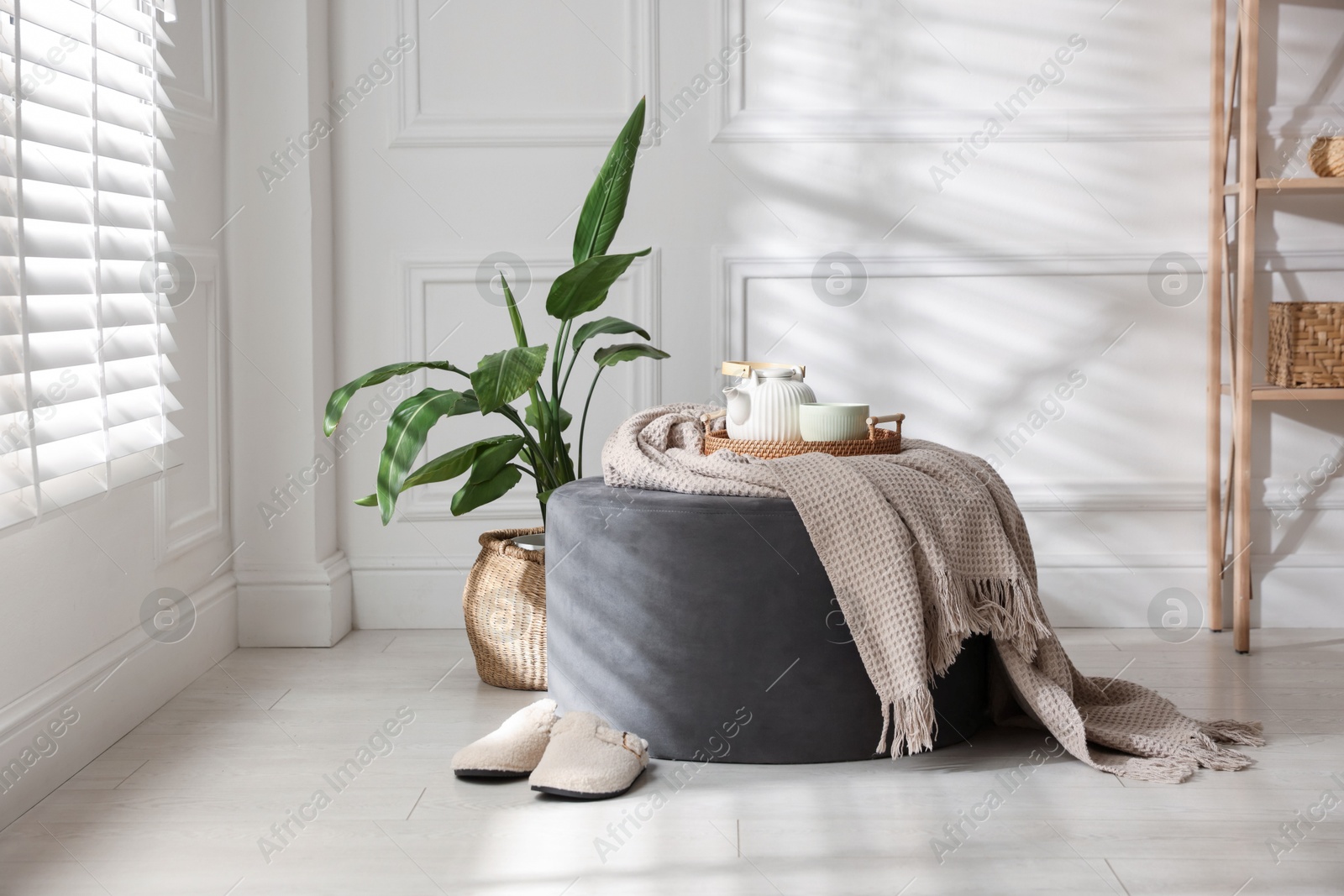Stylish pouf with tea set at home Photo of Stylish pouf with tea set at home