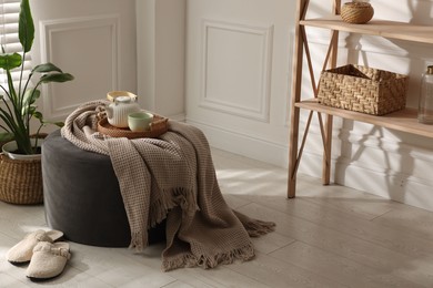 Photo of Stylish pouf with tea set at home