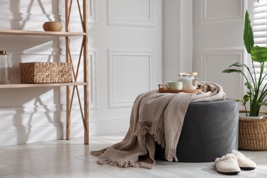 Photo of Stylish pouf with tea set at home