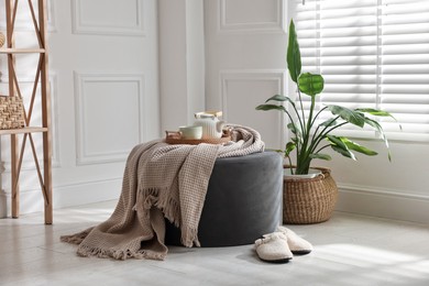 Photo of Stylish pouf with tea set at home
