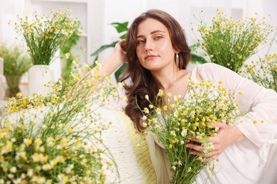 Photo of Portrait of beautiful woman with chamomile flowers indoors