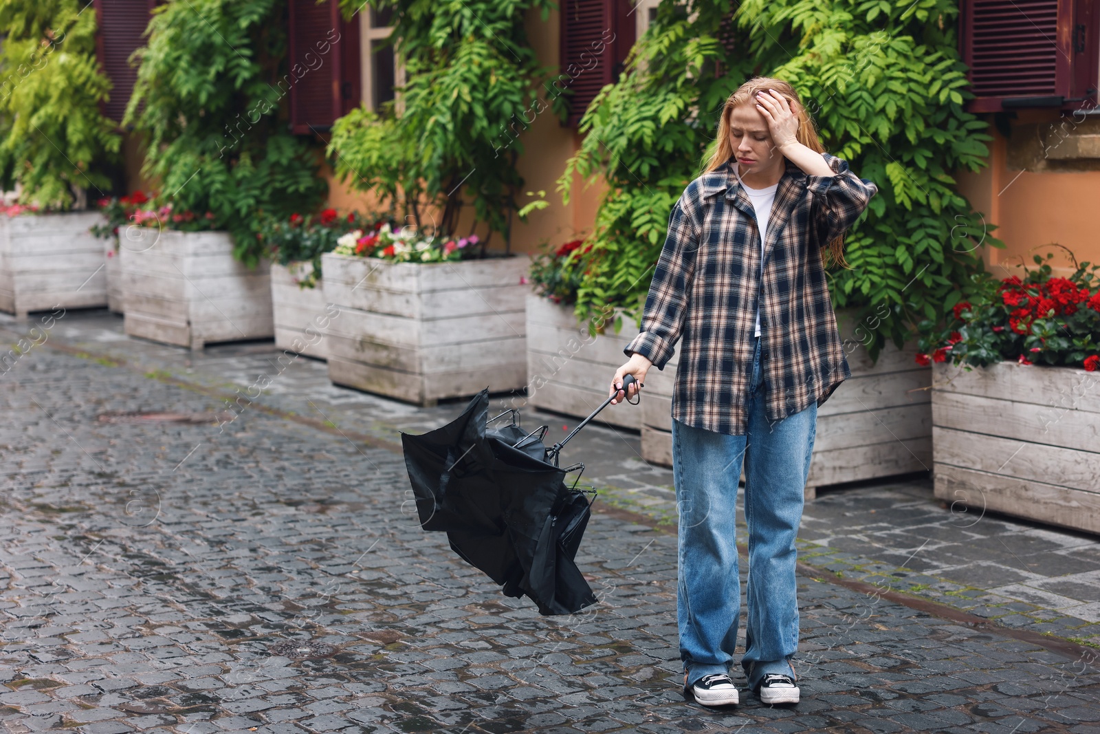 Frustrated woman with broken umbrella on city street. Space for text Photo of Frustrated woman with broken umbrella on city street. Space for text