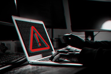 Image of Cyber attack alert notification. Red warning sign and binary code on laptop screen. Hacker using computer, closeup