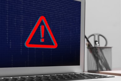 Image of Cyber attack alert notification. Red warning sign and binary code on laptop screen, closeup