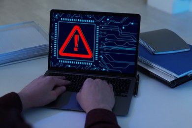 Image of Cyber attack alert notification. Red warning sign and circuit board on laptop screen. Hacker using computer, closeup