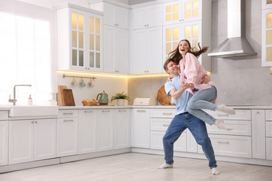 Photo of Happy young couple dancing together in kitchen