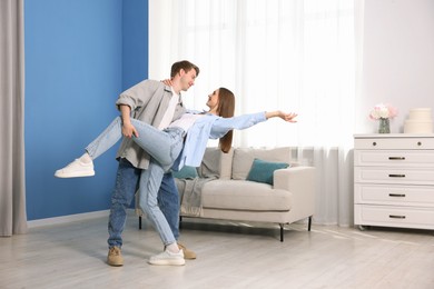 Photo of Happy young couple dancing together at home