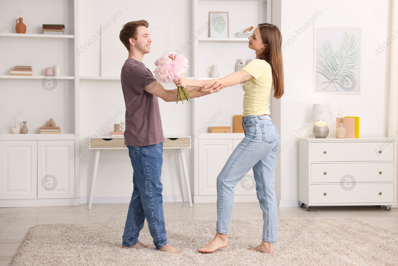 Photo of Happy young couple dancing together at home