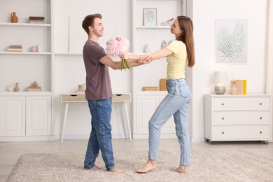 Photo of Happy young couple dancing together at home