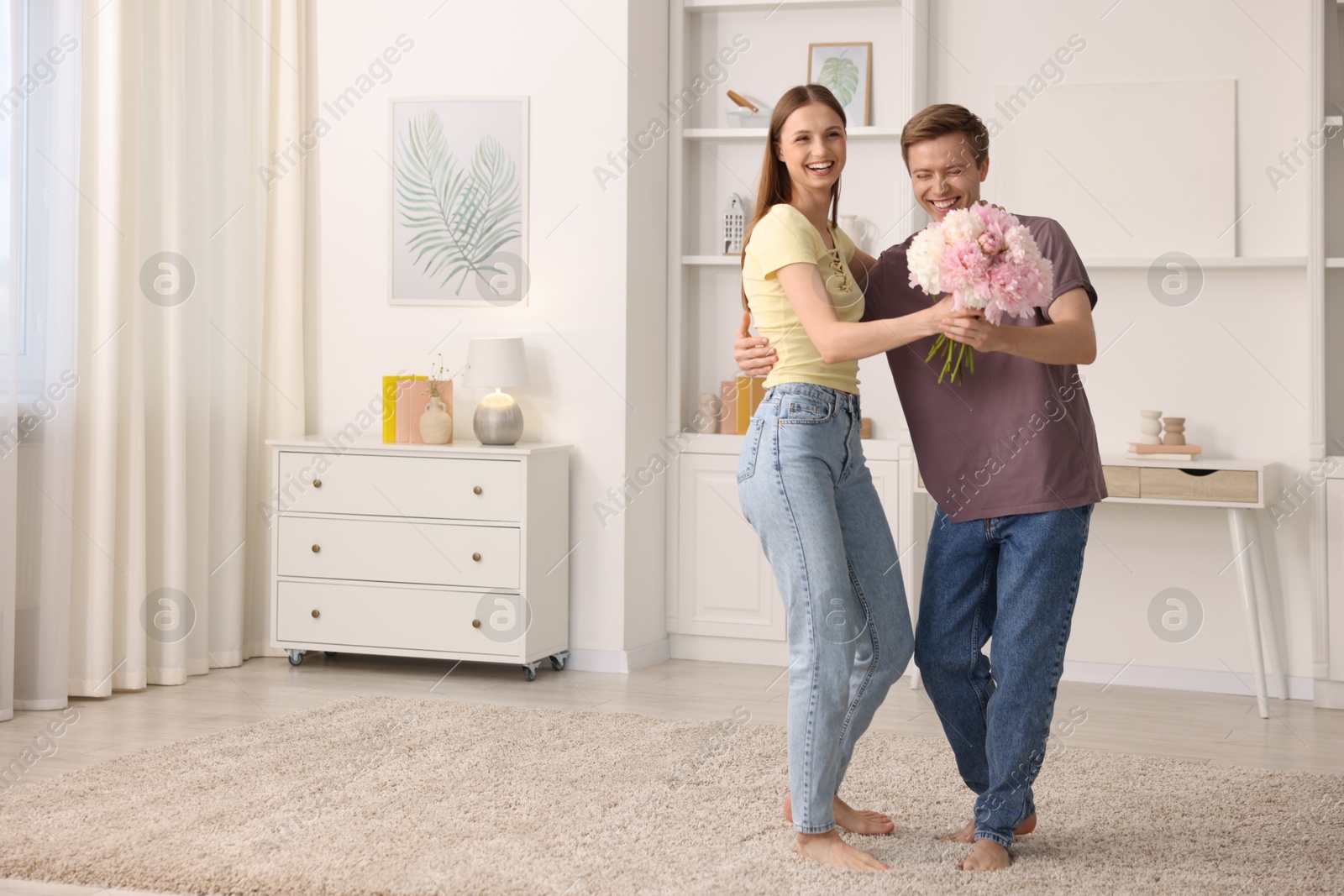 Photo of Happy young couple dancing together at home. Space for text
