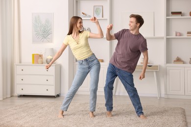 Photo of Happy young couple dancing together at home