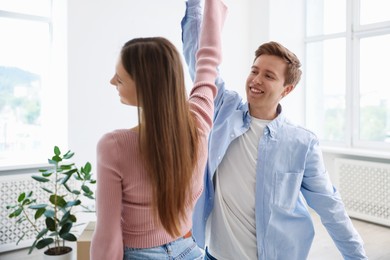 Photo of Happy young couple dancing together at home