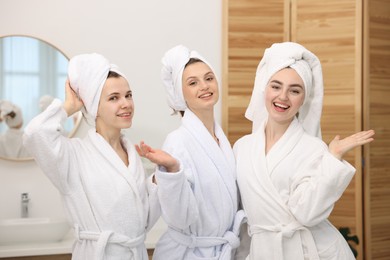 Photo of Happy women in bathrobes after spa procedures indoors