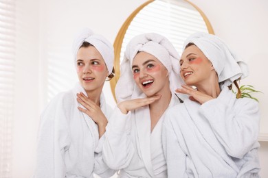 Photo of Happy women in bathrobes after spa procedures indoors