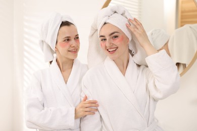 Photo of Happy women in bathrobes after spa procedures indoors