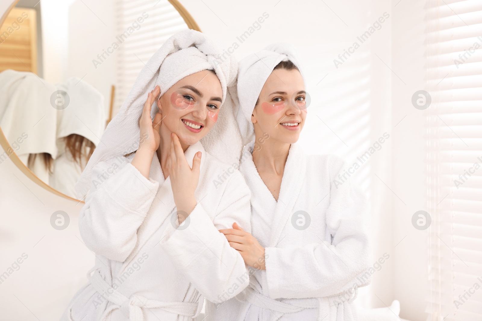 Photo of Happy women in bathrobes after spa procedures indoors