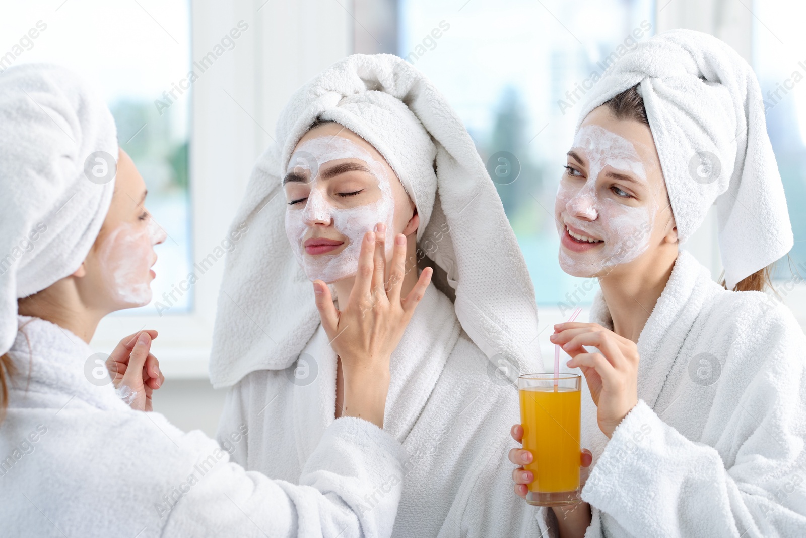 Photo of Happy women in bathrobes spending time together after spa procedures indoors