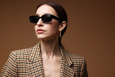 Photo of Portrait of beautiful woman in stylish outfit on brown background