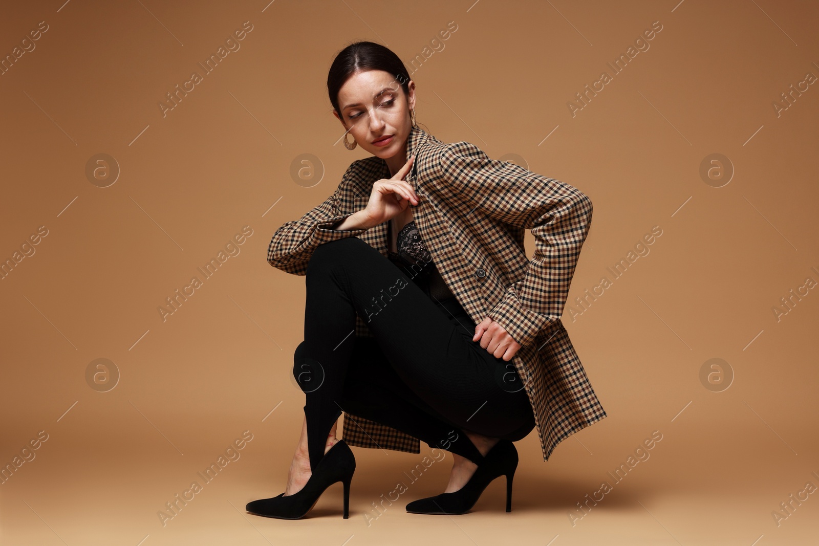 Photo of Full-length portrait of beautiful woman in stylish outfit on beige background