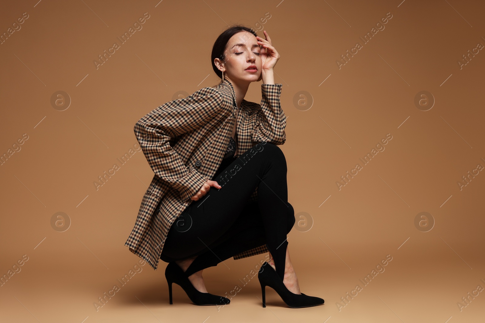 Photo of Full-length portrait of beautiful woman in stylish outfit on beige background
