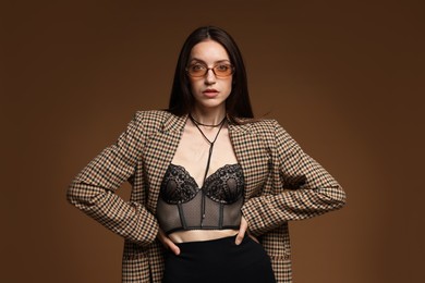 Photo of Portrait of beautiful woman in stylish outfit on brown background