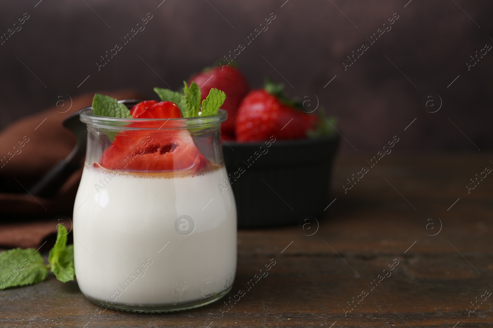 Tasty panna cotta with caramel, strawberries and mint on wooden table, closeup. Space for text Photo of Tasty panna cotta with caramel, strawberries and mint on wooden table, closeup. Space for text