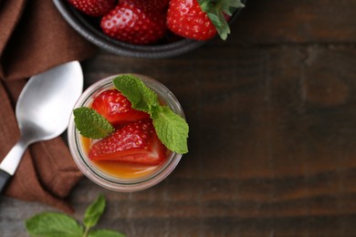 Photo of Tasty panna cotta with caramel, strawberries and mint on wooden table, flat lay. Space for text