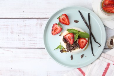Photo of Tasty panna cotta with chocolate, strawberries, mint, caramel and vanilla on white wooden table, flat lay. Space for text