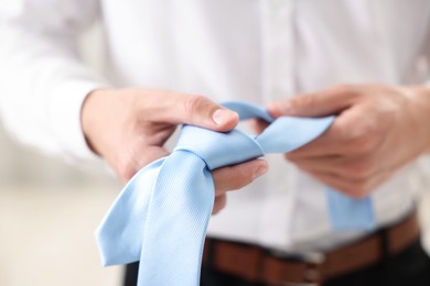 Photo of Man with stylish blue necktie at home, closeup