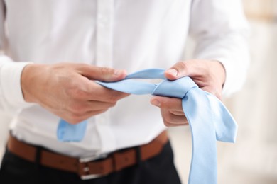 Photo of Man with stylish blue necktie at home, closeup