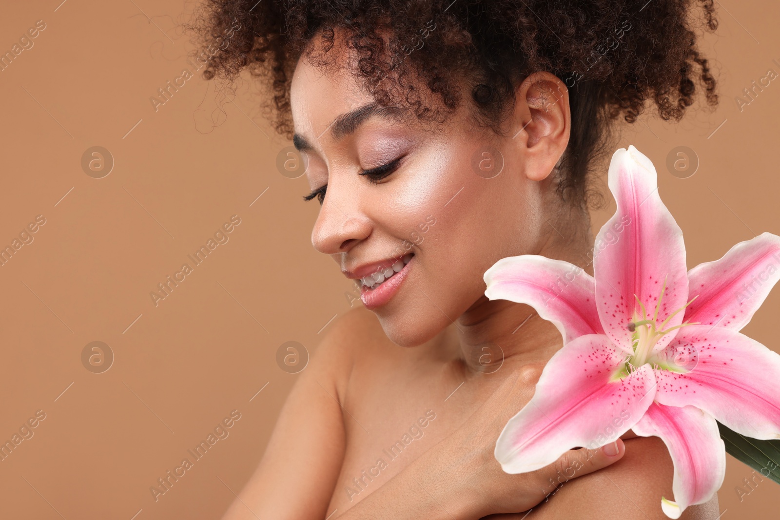 Photo of Portrait of beautiful Brazilian woman with lily flower after spa treatment on light brown background, closeup