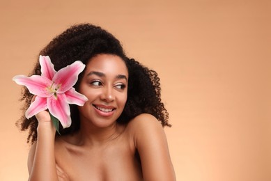 Photo of Portrait of beautiful Brazilian woman with lily flower after spa treatment on beige background. Space for text