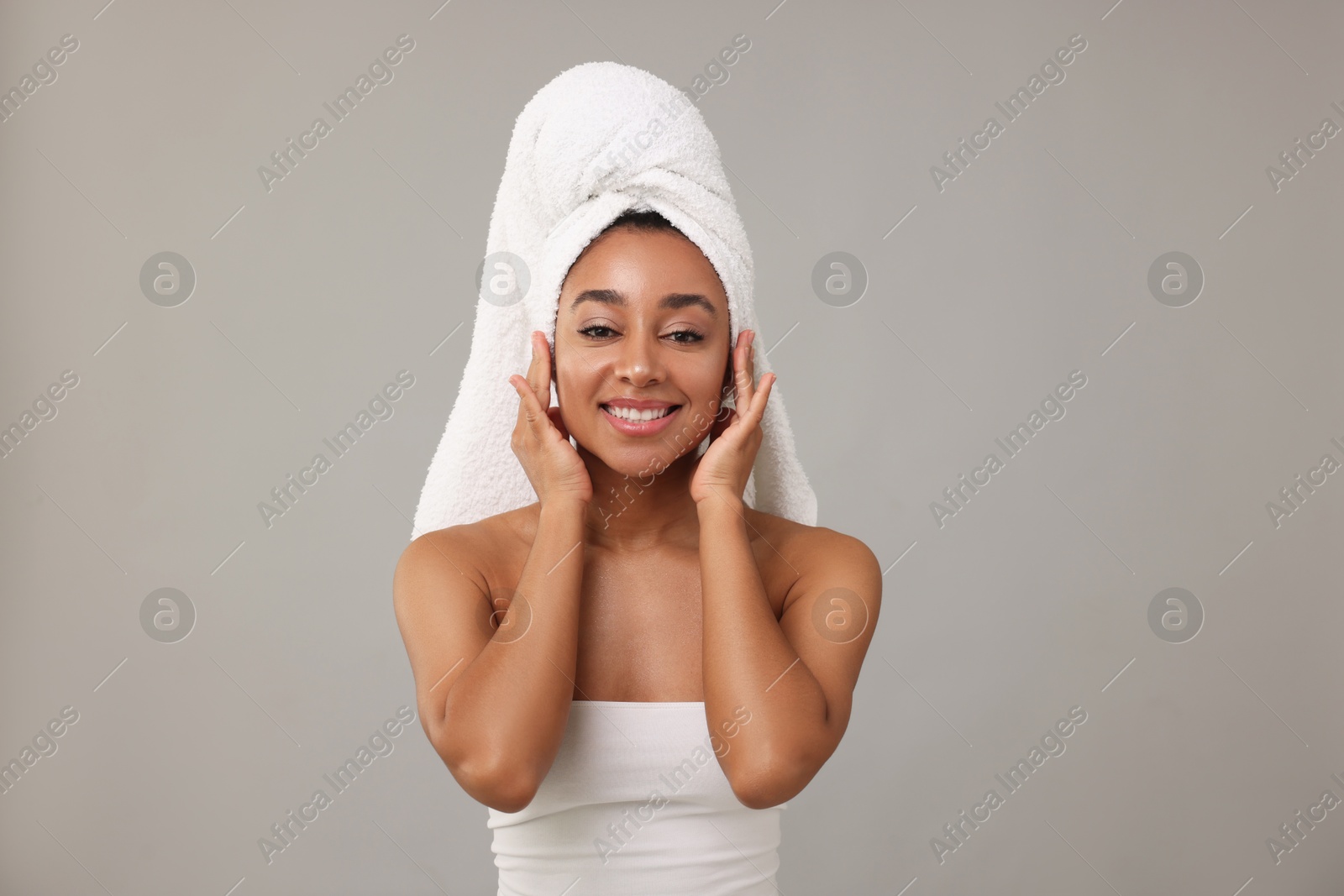 Photo of Portrait of beautiful Brazilian woman after spa treatment on gray background