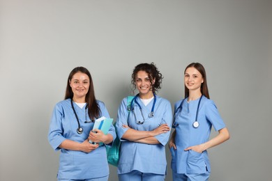 Photo of Group of medical students with books on light grey background