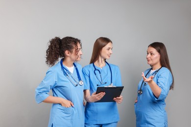 Photo of Group of medical students with clipboard on light grey background