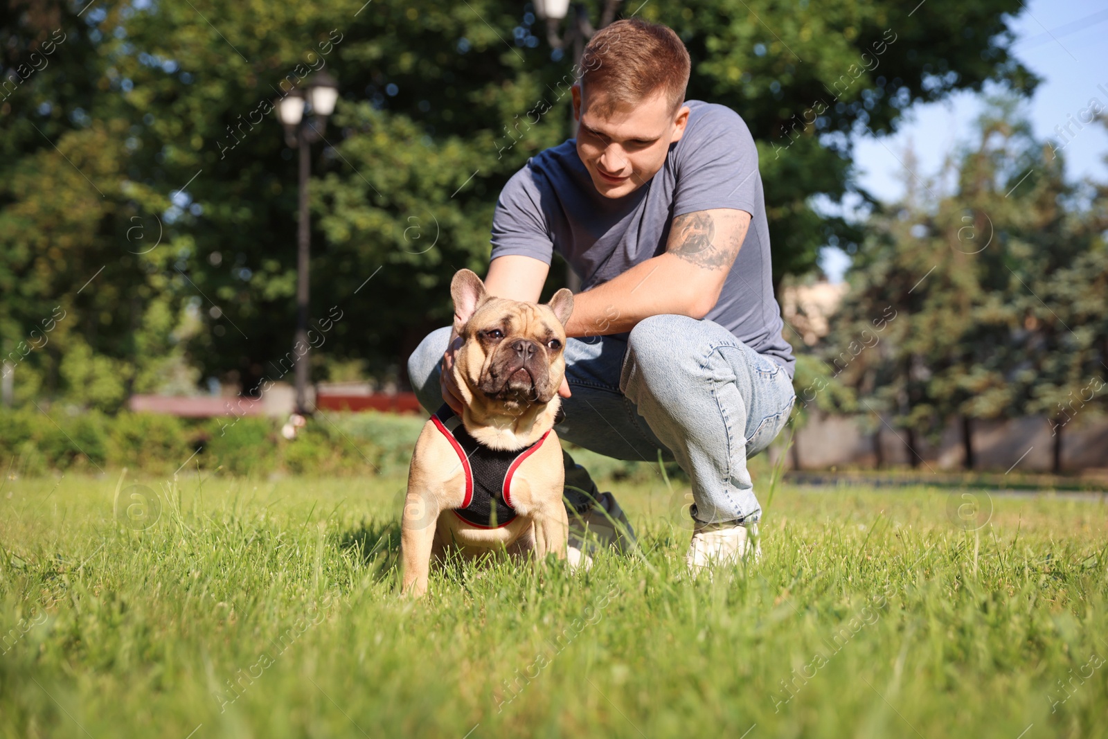 Photo of Happy man with his cute French bulldog in park