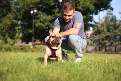 Photo of Happy man with his cute French bulldog in park