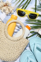 Photo of Beach accessories, sea shells and palm leaves on light blue background, flat lay