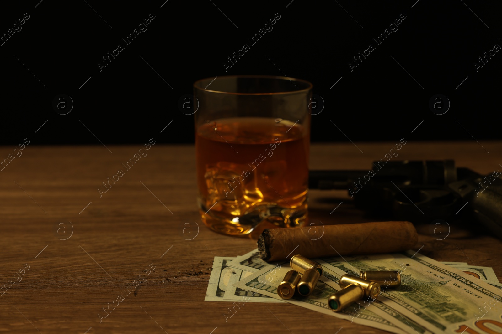 Mafia and criminal world. Gun, bullets, money, cigar and whiskey on wooden table, closeup Photo of Mafia and criminal world. Gun, bullets, money, cigar and whiskey on wooden table, closeup
