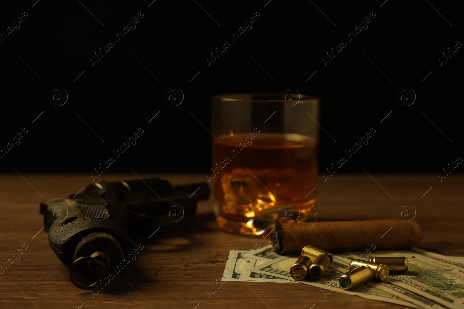 Mafia and criminal world. Gun, bullets, money, cigar and whiskey on wooden table, closeup Photo of Mafia and criminal world. Gun, bullets, money, cigar and whiskey on wooden table, closeup