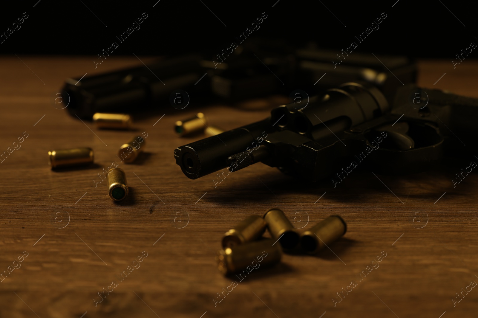 Mafia and criminal world. Guns with bullets on wooden table, closeup Photo of Mafia and criminal world. Guns with bullets on wooden table, closeup